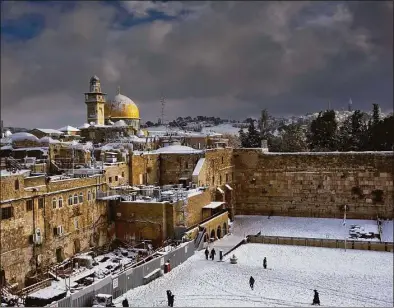  ?? Dusan Vranic / Associated Press ?? In this Dec. 13, 2013 file photo, the Western Wall, right, and the gilded Dome of the Rock, among the holiest sites for Jews and Muslims, are covered in snow. The trapezoid-shaped compound is known to Muslims as the Noble Sanctuary and to Jews as the Temple Mount.