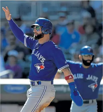  ?? HANNAH FOSLIEN/GETTY IMAGES ?? Kevin Pillar, left, and Jose Bautista, of the Toronto Blue Jays, celebrate after scoring against the Minnesota Twins during the first inning of the game, on Sundayat Target Field in Minneapoli­s, Minn.