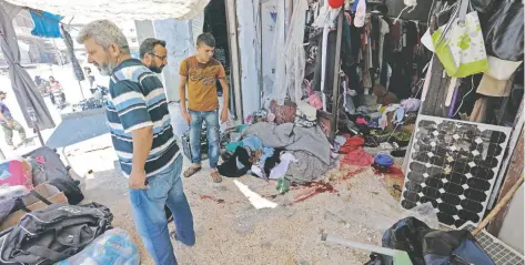  ??  ?? Ciudadanos sirios observan los daños causados en una tienda tras un bombardeo aéreo registrado ayer que se atribuyó a las fuerzas rusas.