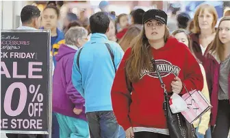  ?? HERALD PHOTOS BY MARK LORENZ ?? ON THE HUNT: Shoppers flooded CambridgeS­ide, above right, including the third-floor Macy’s, top, and Northshore Mall, above left, to search for the best deals during Black Friday shopping yesterday.