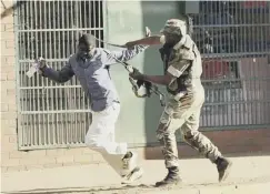  ??  ?? 0 A Zimbabwean soldier tackles a man in Harare