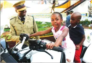  ??  ?? SHOW TIME . . . Hillary and Andrew Kachala enjoy a mock ride on a motorbike under the watchful eye of Sergeant Paul Mbona at the Zimbabwe Republic Police stand on the first day of the Zimbabwe Agricultur­al Show in Harare yesterday. — (Picture by Kudakwashe Hunda; Read show stories on Page 3)