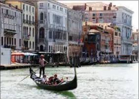  ?? FABRIZIO BENSCH / REUTERS ?? Visitors take a gondola trip on the Grand Canal in Venice on June 21.