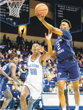  ?? MEG MCLAUGHLIN U-T ?? Toreros guard Eric Williams Jr. (50) tries to keep BYU’S Jaxson Robinson from scoring in Cougars’ 68-48 West Coast Conference victory at Jenny Craig Pavilion on Saturday.