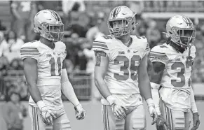  ?? ADAM CAIRNS/COLUMBUS DISPATCH ?? Ohio State linebacker­s C.J. Hicks and Gabe Powers line up next to safety Kye Stokes during the 2022 spring game.