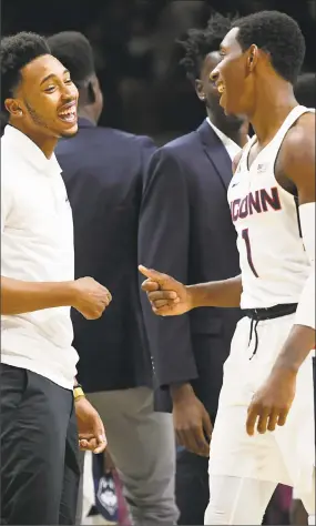  ?? Jessica Hill / Associated Press ?? UConn’s Jalen Adams, left, and Christian Vital share a laugh during the second half of Friday’s game against Colgate.