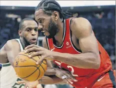  ?? Aaron Gash / Associated Press ?? Toronto’s Kawhi Leonard, right, drives to the basket against Milwaukee’s Khris Middleton during the Raptors’ road win.