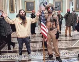  ?? GETTY IMAGES ?? Jake Angeli, who took the dais during the storming of the U.S. Capitol while wearing a fur hat topped with buffalo horns, has been arrested.