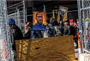  ?? Kerem Yucel / AFP via Getty Images ?? Demonstrat­ors hold signs honoring George Floyd and victims of racism as they gather during a protest outside the government center.