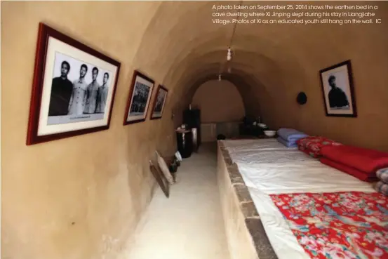  ??  ?? A photo taken on September 25, 2014 shows the earthen bed in a cave dwelling where Xi Jinping slept during his stay in Liangjiahe Village. Photos of Xi as an educated youth still hang on the wall. IC