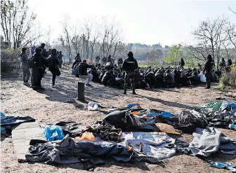  ?? [ via Reuters/Serbisches Innenminis­terium ] ?? An der Grenze zu Ungarn. Serbische Polizisten setzen Migranten fest.