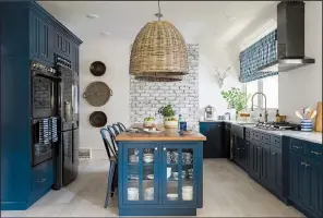  ?? AP/Rustic White Photograph­y/ROBERT PETERSON ?? A kitchen designed by Brian Patrick Flynn features an L-shaped perimeter design with lower cabinets painted a rich shade of navy blue, a style choice that has become increasing­ly popular in recent months.