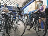  ?? Paul Kuroda / Special to The Chronicle ?? Winston Anyarin assists Alicia Menendez, considerin­g buying her first new bike at Blazing Saddles, a rental shop that is now doing sales and repairs.