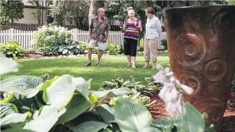  ?? LIAM RICHARDS ?? Brian Gable, left, and Sylva Jurney point out features of their garden to Maureen Mcpherson of Nest Saskatoon. Their yard will be featured in the upcoming Nest Secret Garden Tour, which is a fundraiser for the refugee sponsorshi­p and settlement group.