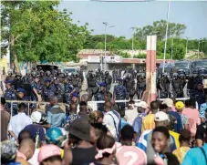  ?? — AFP ?? Police officers block a road as demonstrat­ors march against the high cost of living in Cotonou.