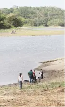  ??  ?? Ciudadanos parados sobre lo que una vez estuvo cubierto de agua.