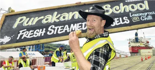  ?? PHOTO: STEPHEN JAQUIERY ?? Ahoy mateys . . . Port Chalmers Seafood Festival volunteer Dave Kearns enjoys a whitebait fritter as other volunteers also take a break from setting up the festival on the Port Chalmers wharf yesterday.