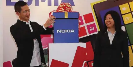  ??  ?? LATEST ENTRY: Chan unveiling the Nokia Lumia 620 with Ng.