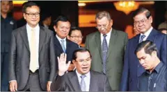  ?? HENG CHIVOAN ?? Prime Minister Hun Sen waves as he leaves the Senate in 2014 after concluding negotiatio­ns with former senior members of the court-dissolved CNRP.