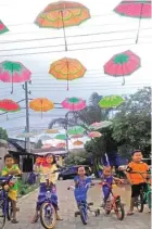  ?? FIRMA ZUHDI/JAWA POS ?? BUAH KREATIVITA­S: Anak-anak menikmati lahan yang berhias payung di Desa Wedoro, Waru.