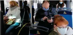  ?? FOTO: SEBASTIAN WILLNOW / DPA ?? Fahrgäste eines Linienbuss­es sitzen eng beieinande­r, tragen aber den vorgeschri­ebnen Mundschutz