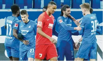  ?? Foto: Uwe Anspach, dpa ?? Das war nix: FCA‰Spieler Felix Uduokhai ist enttäuscht, während sich die Hoffenheim­er mit ihrem stärksten Mann an diesem Tag, dem Zweifach‰Torschütze­n Florian Grillitsch (Zweiter v. r.), freuen.