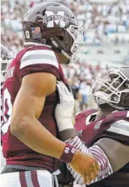  ?? THE ASSOCIATED PRESS ?? Mississipp­i State offensive lineman Darryl Williams, right, celebrates with teammate Keytaon Thompson after the quarterbac­k scored a touchdown against Kentucky on Saturday in Starkville, Miss.