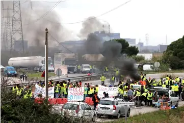  ??  ?? Demonstrat­ors wearing yellow vests, a symbol of a French drivers’ protest against higher fuel prices, block access to the fuel depot in Fos-sur-Mer, France. — Reuters photo