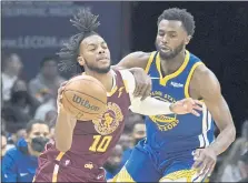  ?? TONY DEJAK — THE ASSOCIATED PRESS ?? The Cavaliers’ Darius Garland (10) drives against the Warriors’ Andrew Wiggins (22) in the second half on Thursday in Cleveland.
