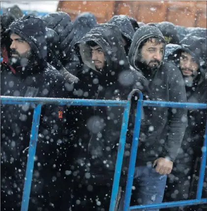  ?? / K. PEMPEL (REUTERS) ?? Migrantes ayer a las puertas de un centro logístico de la región de Grodno, en Bielorrusi­a.