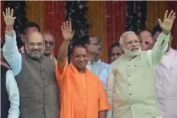  ?? SANJAY KANOJIA/GETTY IMAGES ?? Bharatiya Janata Party (BJP) president Amit Shah, Yogi Adityanath and Indian Prime Minister Narendra Modi attend Adityanath’s swearing-in ceremony.