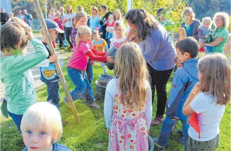  ?? FOTO: JANA MACK ?? Nicole Schäfer wurde von den älteren Kindern tatkräftig beim Pflanzen des neuen Apfelbaums unterstütz­t.