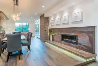  ??  ?? The main level hosts wide-plank, engineered, oak hardwood floors and hearth next to the dining room. Dekton manufactur­ed stone clads the fireplace with the hearth accented by LED under mount lighting.