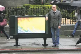  ?? Lea Suzuki / The Chronicle ?? Bob Schmitt, Northern California regional president of Clear Channel Outdoor, with one of the digital billboards the company is installing on the back of newspaper racks around San Francisco.