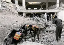  ?? Muhammad Sajjad / Associated Press ?? Rescue workers and people gather at the site of Monday’s suicide bombing after authoritie­s finished the rescue operation in Peshawar, Pakistan, Tuesday. The bombing that struck inside a mosque at a police and government compound reflects “security lapses,” officials said.