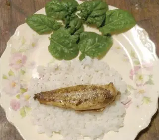  ?? DALE BOWMAN/FOR THE SUN-TIMES ?? Perch are best done simply, such as this plate with skin-on, bone-in perch, pan-fried in butter, presented on a bed of rice garnished with December-cut, organic, home-grown spinach.