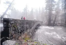  ?? SILVIA FLORES/THE FRESNO BEE ?? The Merced River flows under the Pohono Bridge in Yosemite National Park in California on Sunday, after an unrelentin­g series of storms filled lakes, overflowed rivers and buried mountains in snow.