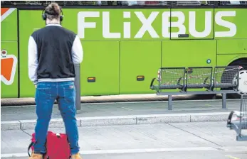  ?? FOTO: FABIAN SOMMER/DPA ?? Reisender wartet vor einem Flixbus: Sind zusätzlich­e Gebühren beim Zahlen per Paypal in Ordnung oder nicht? Die Verbrauche­rzentrale meint nicht und hat den Fernbusanb­ieter Flixbus verklagt.
