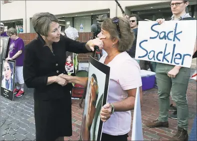  ?? Charles Krupa / Associated Press ?? Massachuse­tts Attorney General Maura Healey, left, wipes a tear from the face of Wendy Werbiskis, of East Hampton, Mass., one of the protesters gathered outside a courthouse in Boston, where a judge was to hear arguments in the state's lawsuit against Purdue Pharma over its role in the national drug epidemic on Aug. 2. Reports emerging about a possible financial settlement with Purdue, the company that has come to symbolize the nation's opioid epidemic, suggests the settlement amount won't come anywhere near what the national crisis has cost.