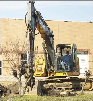  ?? Brodie Johnson • Times-Herald ?? Work to remodel the main building on the former Crowley's Ridge Technical Institute campus into a welcome center for East Arkansas Community College is progressin­g as work on the parking lot gets underway. A worker with Triple G Excavation digs up asphalt from the parking lot so the area can be repaved.