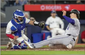  ?? FRANK GUNN — THE CANADIAN PRESS VIA AP ?? The Rockies’ Michael Toglia slides in to score under a tag by Blue Jays catcher Alejandro Kirk during the seventh inning in Toronto on Friday.