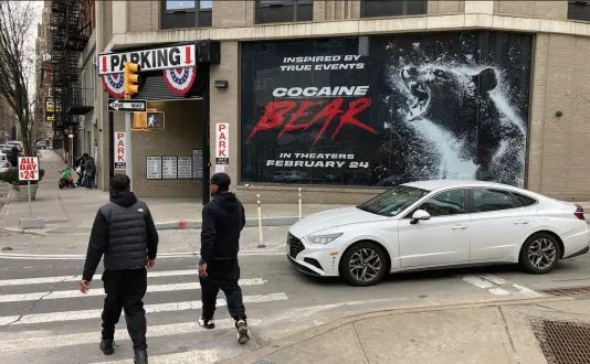  ?? TED SHAFFREY / ASSOCIATED PRESS ?? Pedestrian­s walk near a billboard advertisem­ent for the movie “Cocaine Bear” on Feb. 12 in New York City. The movie, featuring Ray Liotta in one of his final performanc­es filmed before his May 2022 death at age 67, brought the internet to its knees with an amazing trailer.