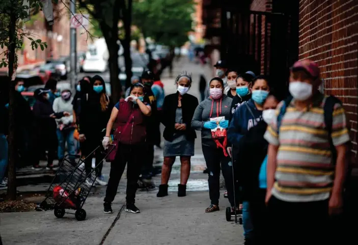  ?? Photograph: Johannes Eisele/AFP/Getty Images ?? People line up for food donations on 19 May in the Bronx borough of New York City.