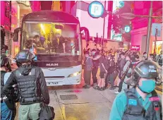  ?? — AFP file photo ?? Police detain people on a bus after they cleared protesters taking part in a rally against a new national security law in Hong Kong.