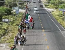  ?? Guillermo Arias / AFP / Getty Images ?? Migrants — mostly Hondurans — take part in a caravan heading through Mexico to the U.S. on Thursday. President Donald Trump demonized the caravan as filled with “tough people.”