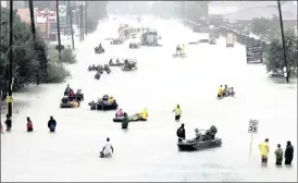  ?? PHOTO: AP ?? Rescue boats fill a flooded street as flood victims are evacuated while floodwater­s from tropical storm Harvey rise in Houston on Monday. Damages from Harvey are estimated by insurance firms to be below those from the major storms that hit New Orleans...