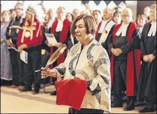  ?? LEN WAGG/COMMUNICAT­IONS NOVA SCOTIA VIA CP ?? Marlys Edwardh, one of the lawyers for Donald Marshall Jr., whose wrongful murder conviction was overturned by the Nova Scotia Court of Appeal in 1983, holds a feather at a ceremony opening a native court at the Wagmatcook First Nation in Cape Breton.