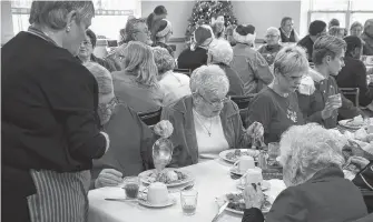  ??  ?? Maureen Publow, left, serves a table during a previous Christmas Day dinner hosted by the Bridgetown woman and her husband Jerry Publow.