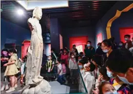  ?? WANG JILIN / FOR CHINA DAILY ?? Visitors admire a statue at Qingzhou Museum in Qingzhou, Shandong province, on May 18.