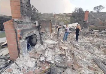  ?? — AFP ?? Members of the Reinhardt family sort through the remains of their family home after the Thomas wildfire swept through Ventura, California.